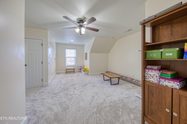 rec room featuring ceiling fan, light colored carpet, and a textured ceiling