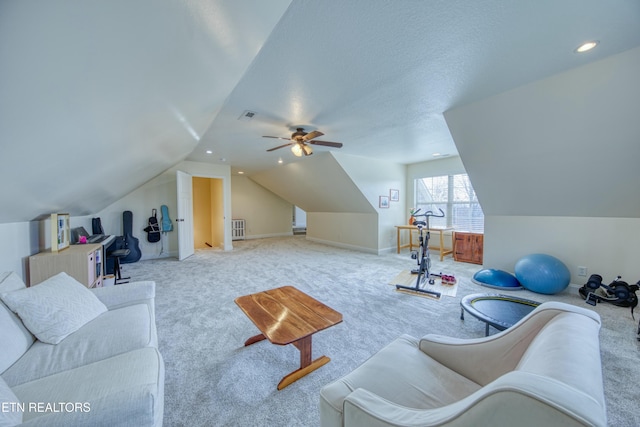 living room with ceiling fan, vaulted ceiling, light colored carpet, and a textured ceiling