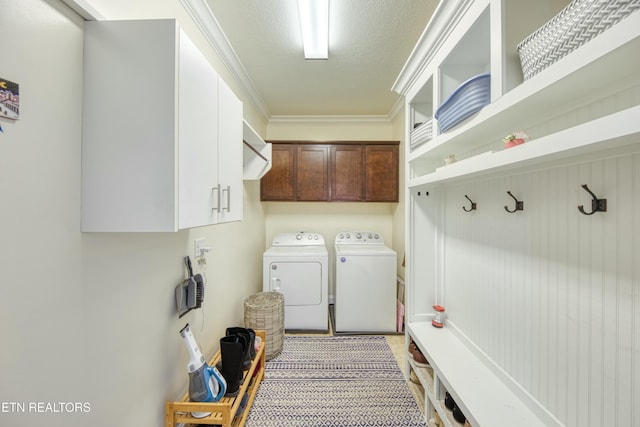 laundry area featuring cabinets, crown molding, and washer and dryer