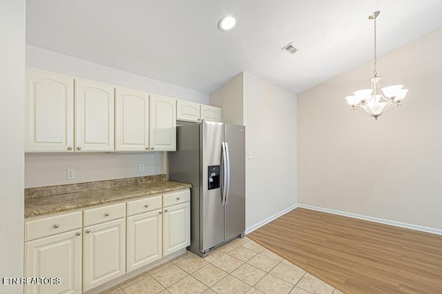 kitchen featuring pendant lighting, white cabinetry, an inviting chandelier, stainless steel refrigerator with ice dispenser, and light wood-type flooring