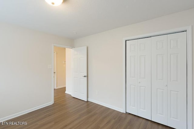 unfurnished bedroom featuring hardwood / wood-style flooring and a closet