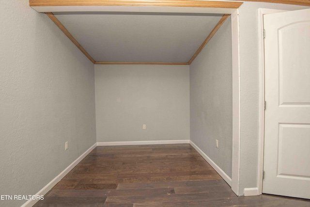 spare room featuring dark wood-type flooring and ornamental molding