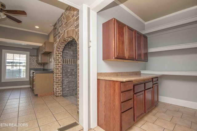 kitchen with light tile patterned floors, ornamental molding, and ceiling fan