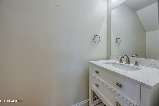 bathroom with lofted ceiling and vanity