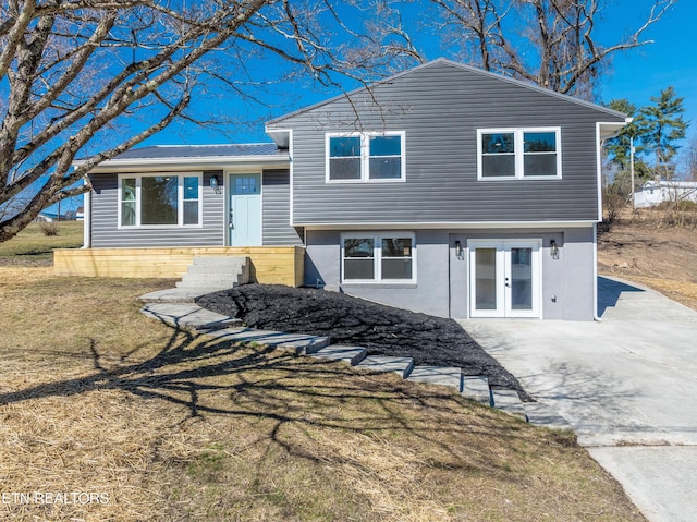 split level home with a front lawn and french doors