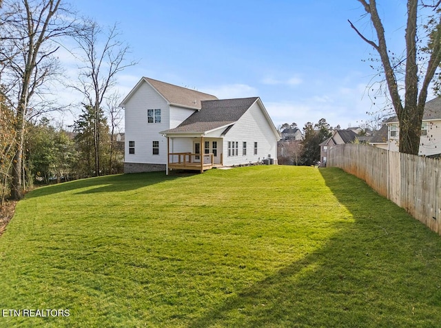 rear view of property featuring a deck and a lawn