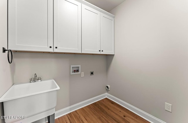 clothes washing area featuring cabinets, hookup for an electric dryer, hookup for a washing machine, sink, and wood-type flooring