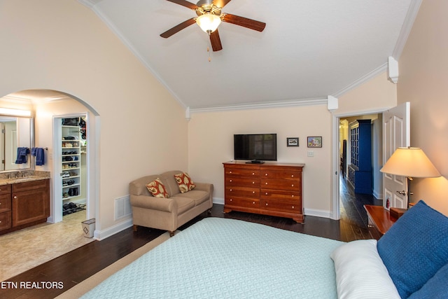 bedroom with crown molding, dark hardwood / wood-style flooring, a spacious closet, vaulted ceiling, and a closet