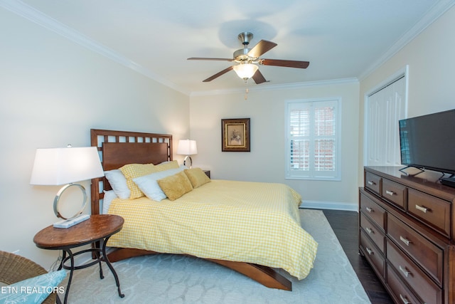 bedroom with crown molding, dark wood-type flooring, ceiling fan, and a closet