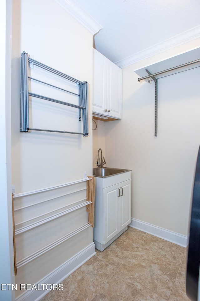 washroom with ornamental molding and sink