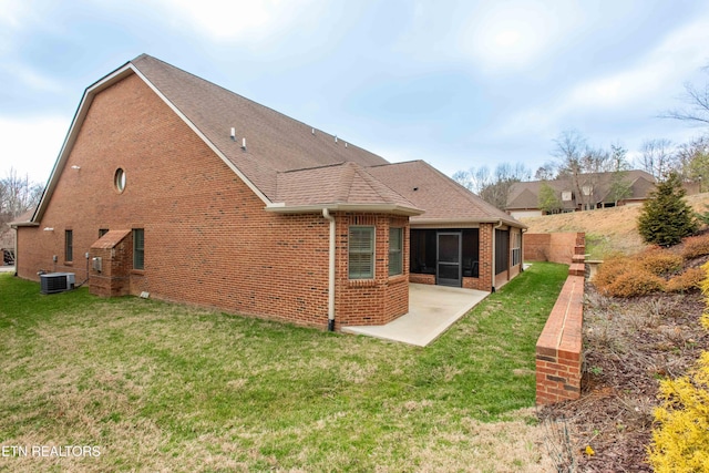 rear view of house with a patio, a sunroom, cooling unit, and a lawn