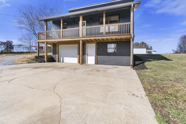 view of front property featuring a garage, a front yard, and a balcony