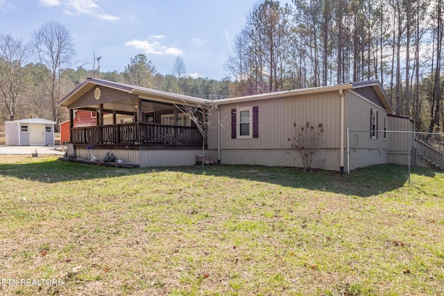 rear view of property with a lawn and fence