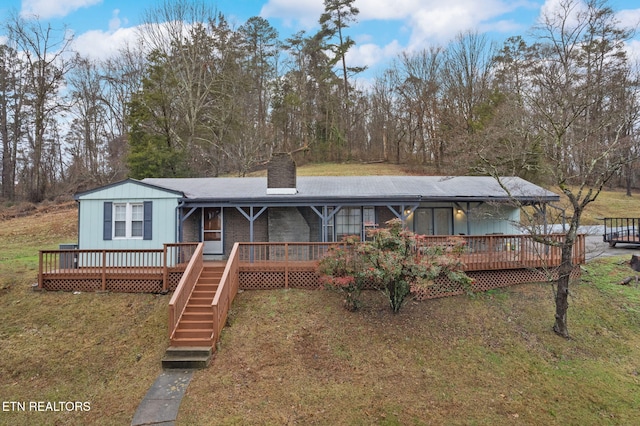 view of front facade featuring a wooden deck and a front lawn