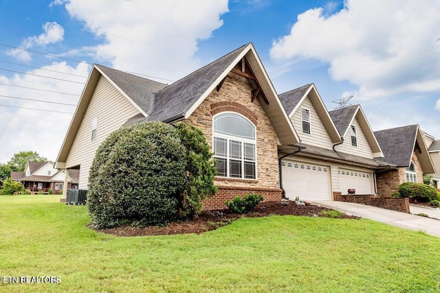 view of front of home with a garage, cooling unit, and a front yard