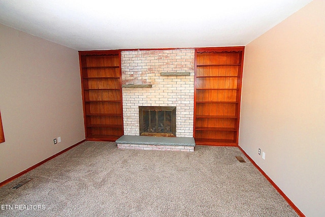 unfurnished living room featuring light colored carpet, built in features, and a fireplace