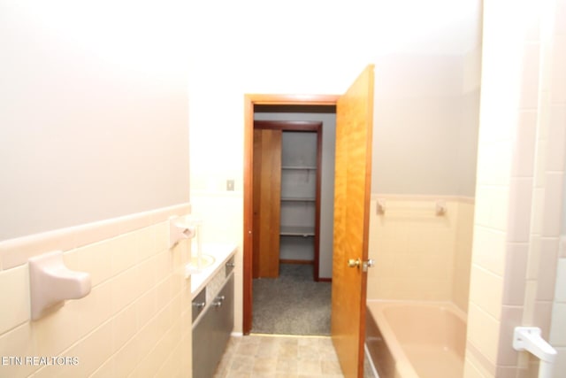 bathroom featuring tile walls and a bathing tub