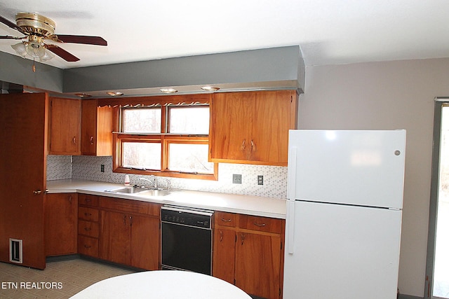 kitchen featuring sink, ceiling fan, dishwasher, white refrigerator, and decorative backsplash