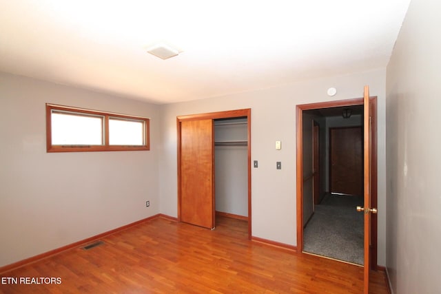 unfurnished bedroom with hardwood / wood-style floors and a closet