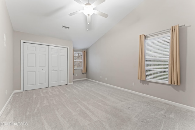 unfurnished bedroom with lofted ceiling, light carpet, ceiling fan, and a closet