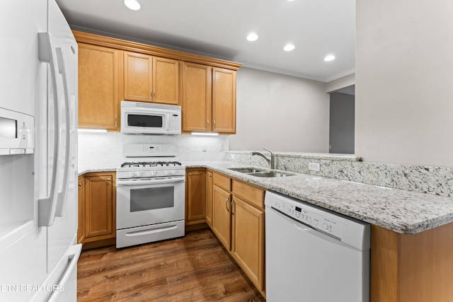 kitchen featuring sink, white appliances, dark wood-type flooring, tasteful backsplash, and light stone countertops