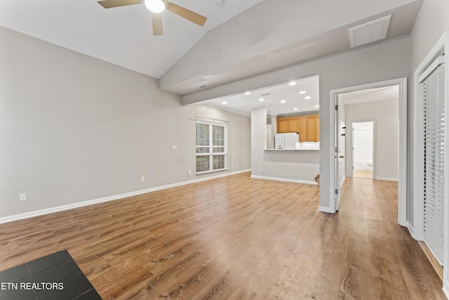 unfurnished living room featuring ceiling fan, vaulted ceiling, and light wood-type flooring