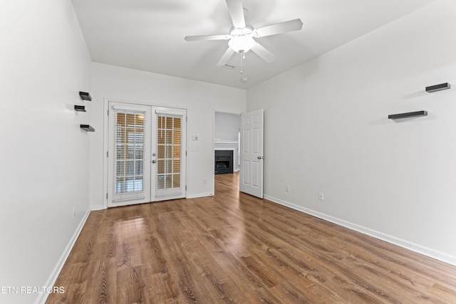 empty room with hardwood / wood-style flooring, ceiling fan, and french doors