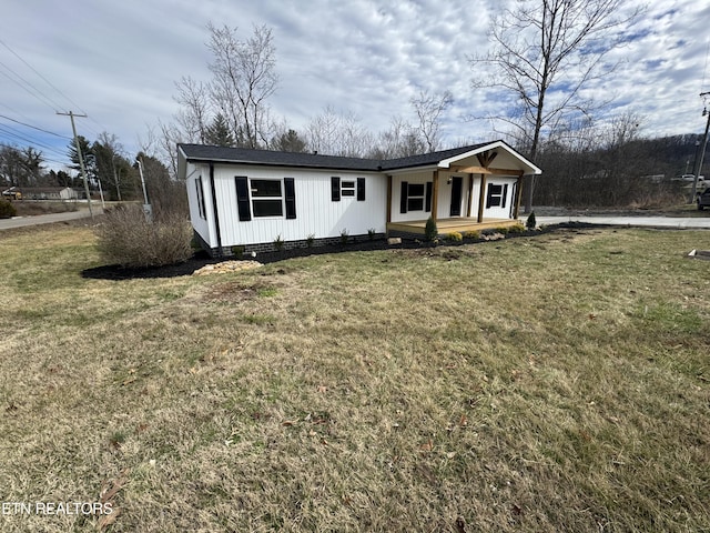 view of front of house featuring covered porch and a front lawn