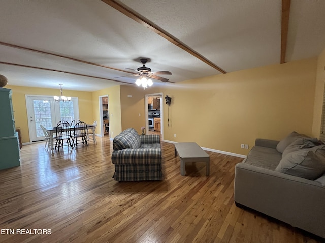 living room with ceiling fan with notable chandelier and wood-type flooring