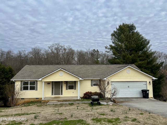 ranch-style house featuring covered porch and a garage