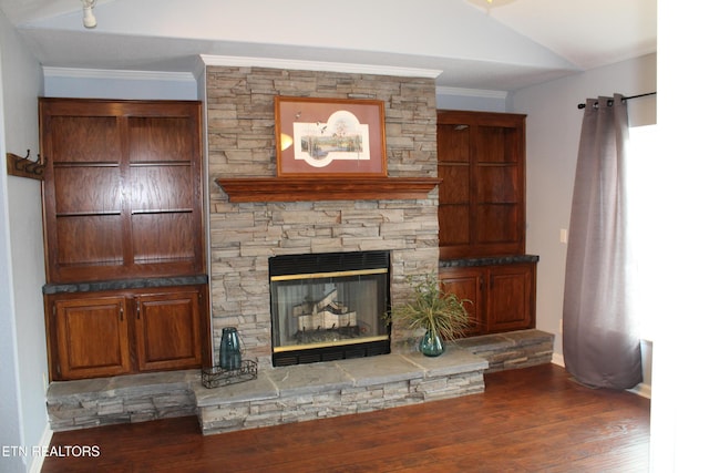 unfurnished living room with dark wood-type flooring, lofted ceiling, a stone fireplace, and crown molding