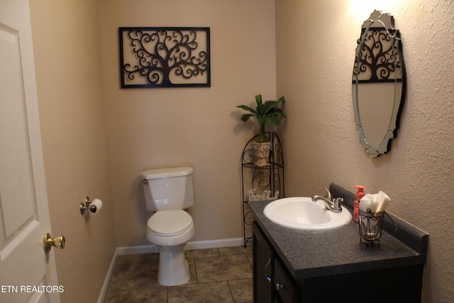 bathroom featuring vanity, tile patterned floors, and toilet