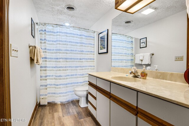 1130 Ski View Dr, Gatlinburg, TN 37738 - full bath with visible vents, toilet, vanity, a textured ceiling, and wood finished floors