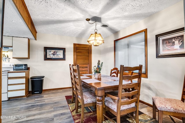 1130 Ski View Dr, Gatlinburg, TN 37738 - dining area featuring a toaster, baseboards, dark wood-type flooring, a textured ceiling, and a chandelier