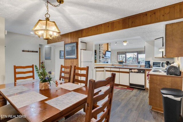 1130 Ski View Dr, Gatlinburg, TN 37738 - dining space featuring dark wood-style floors, wood walls, a textured ceiling, and ceiling fan with notable chandelier