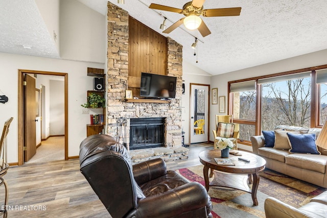 1130 Ski View Dr, Gatlinburg, TN 37738 - living room featuring light wood-style floors, a fireplace, a textured ceiling, and ceiling fan