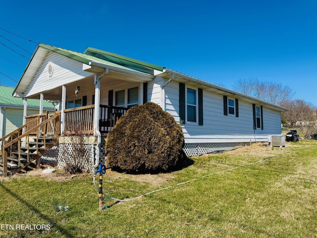 view of side of home featuring a porch and a lawn