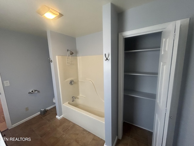 bathroom with shower / bathing tub combination, tile patterned flooring, and toilet