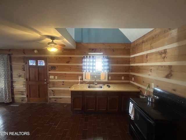 kitchen featuring ceiling fan, sink, wooden walls, and black range with electric cooktop