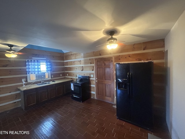 kitchen featuring ceiling fan, wooden walls, sink, and black appliances