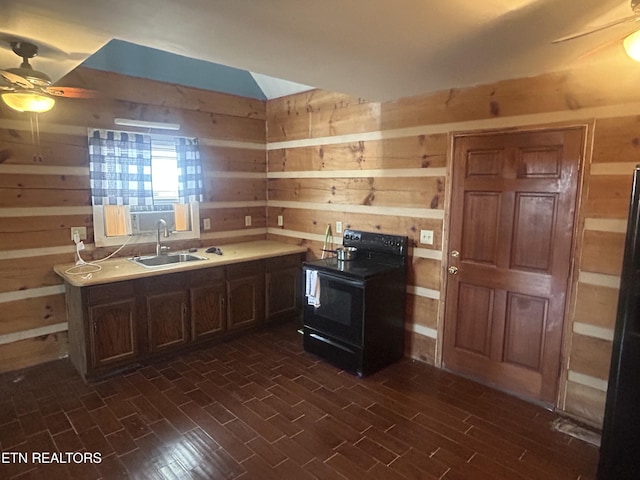 kitchen with dark wood-type flooring, sink, wooden walls, ceiling fan, and black appliances