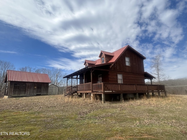 back of property with a lawn and a storage unit