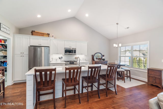 kitchen featuring stainless steel appliances, light countertops, dark wood finished floors, and white cabinets