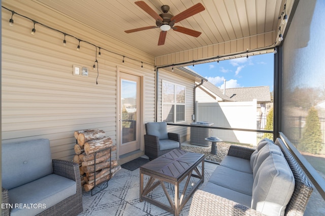 sunroom / solarium featuring a ceiling fan, wooden ceiling, rail lighting, and plenty of natural light