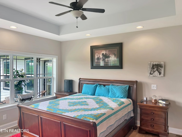 bedroom with a raised ceiling and ceiling fan