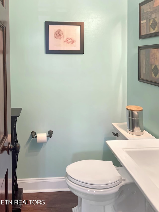 bathroom featuring hardwood / wood-style flooring and toilet