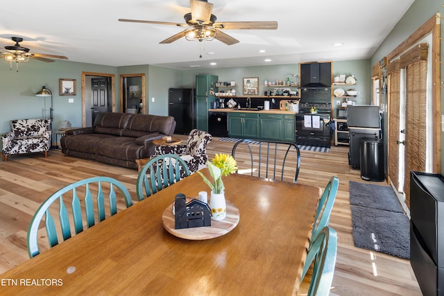 dining area featuring light hardwood / wood-style floors, sink, and ceiling fan