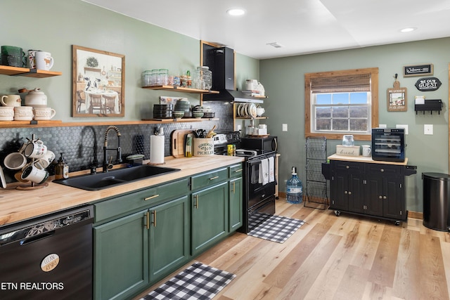 kitchen with black appliances, wall chimney range hood, decorative backsplash, sink, and light wood-type flooring