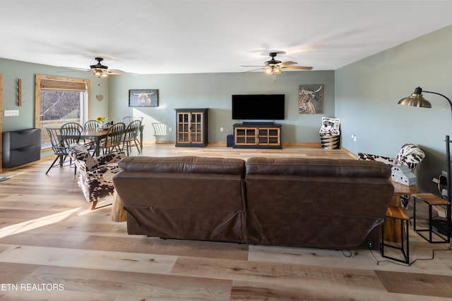 living room featuring light hardwood / wood-style floors and ceiling fan