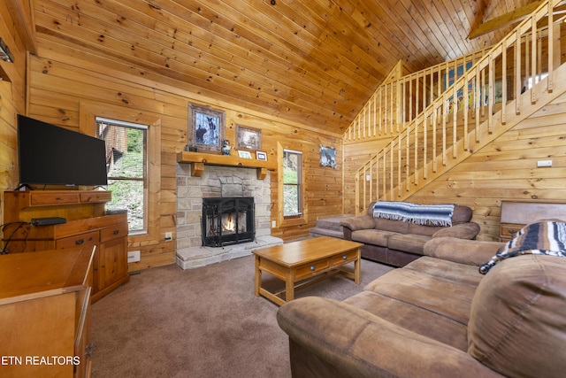 carpeted living room featuring wood ceiling, wooden walls, high vaulted ceiling, and a stone fireplace